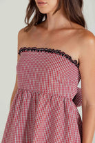 Red and white checkered dress with black trim on a plain background