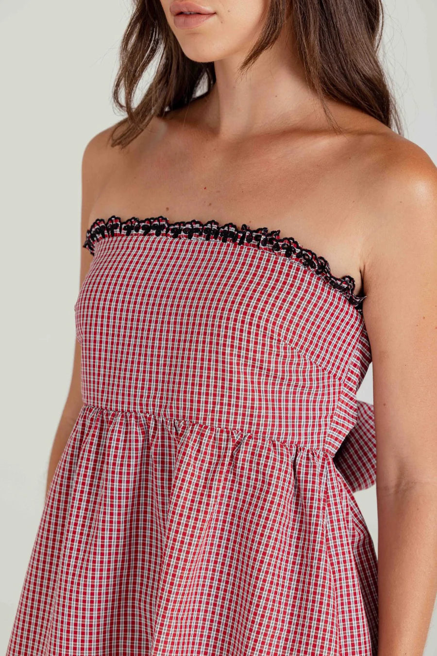 Red and white checkered dress with black trim on a plain background