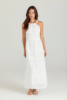 Woman wearing a white dress on a plain background