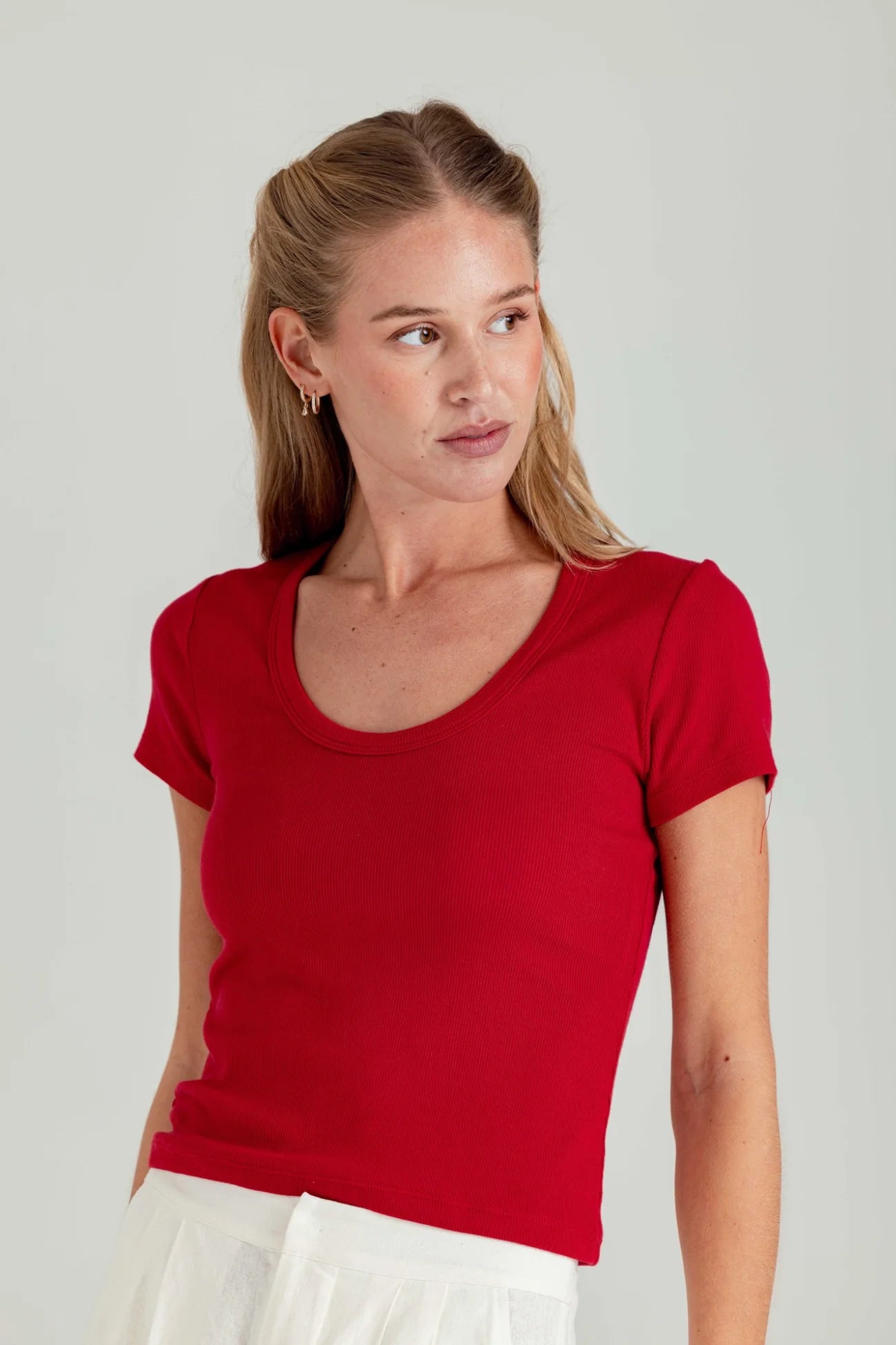 Woman wearing a red t-shirt against a plain background