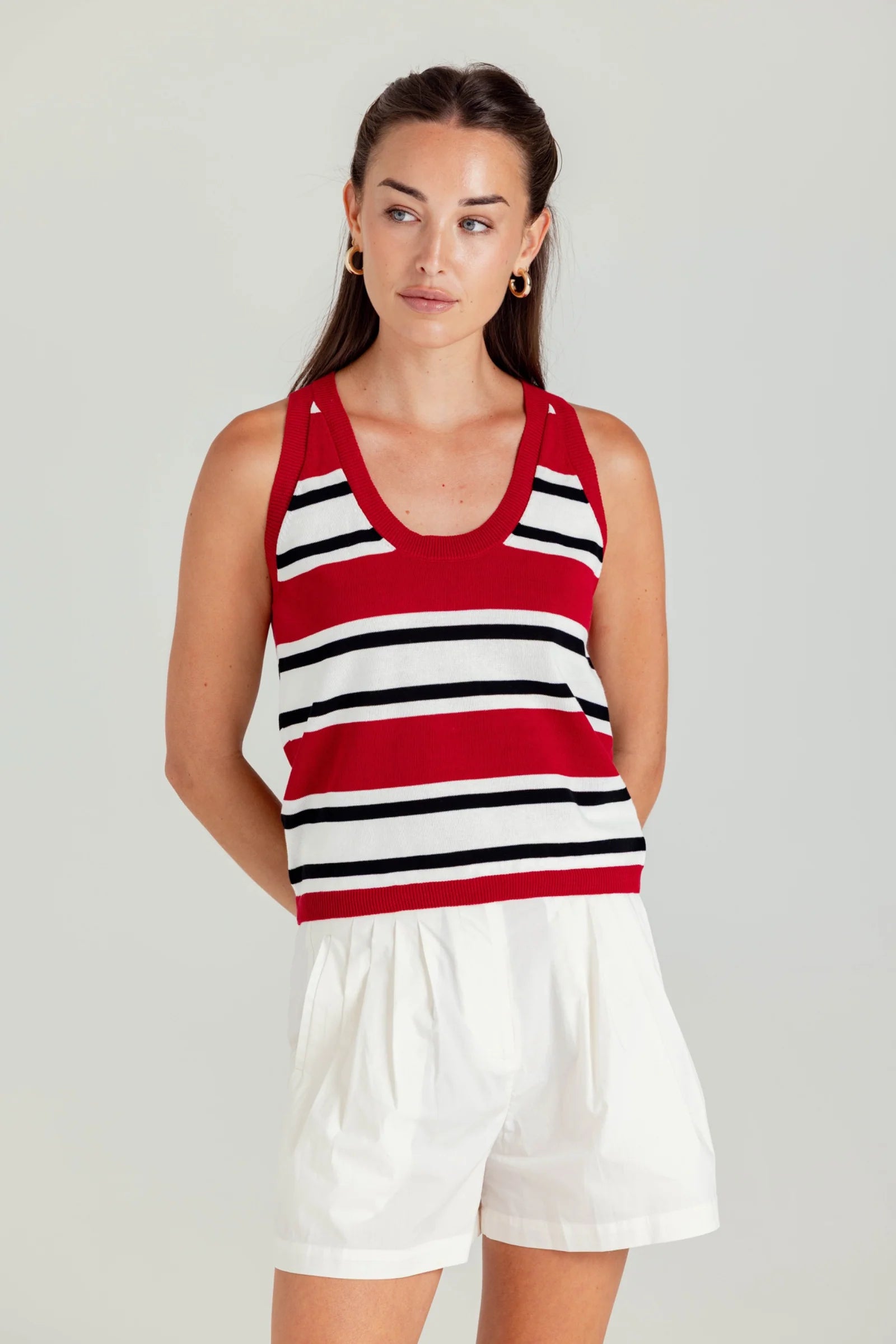 Woman wearing a red, white, and black striped dress with a plain background