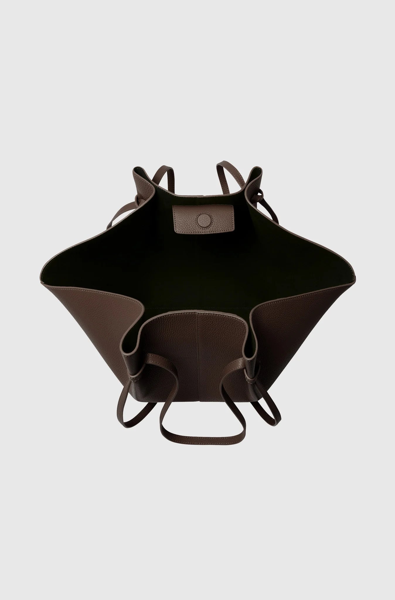 Black leather bag with brown accents on a light gray background