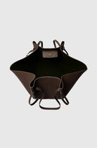 Black leather bag with brown accents on a light gray background