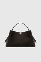 Black handbag with a strap on a light gray background
