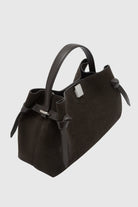 Black handbag with bow detail on a light gray background