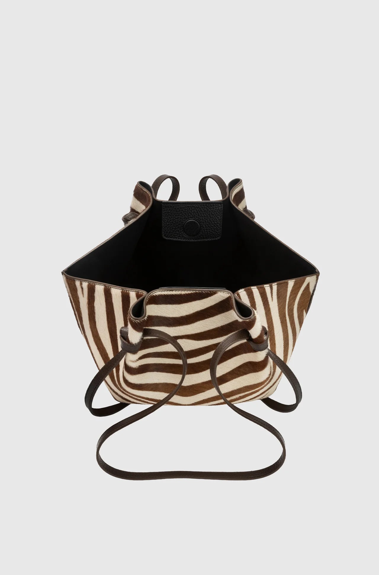 Black and zebra-patterned bag with a strap on a light gray background