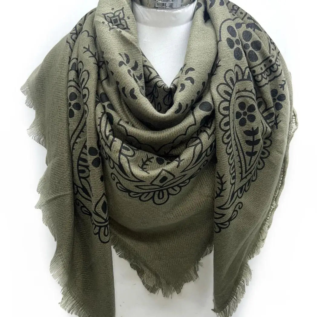 Green scarf with black patterns on a mannequin against a white background