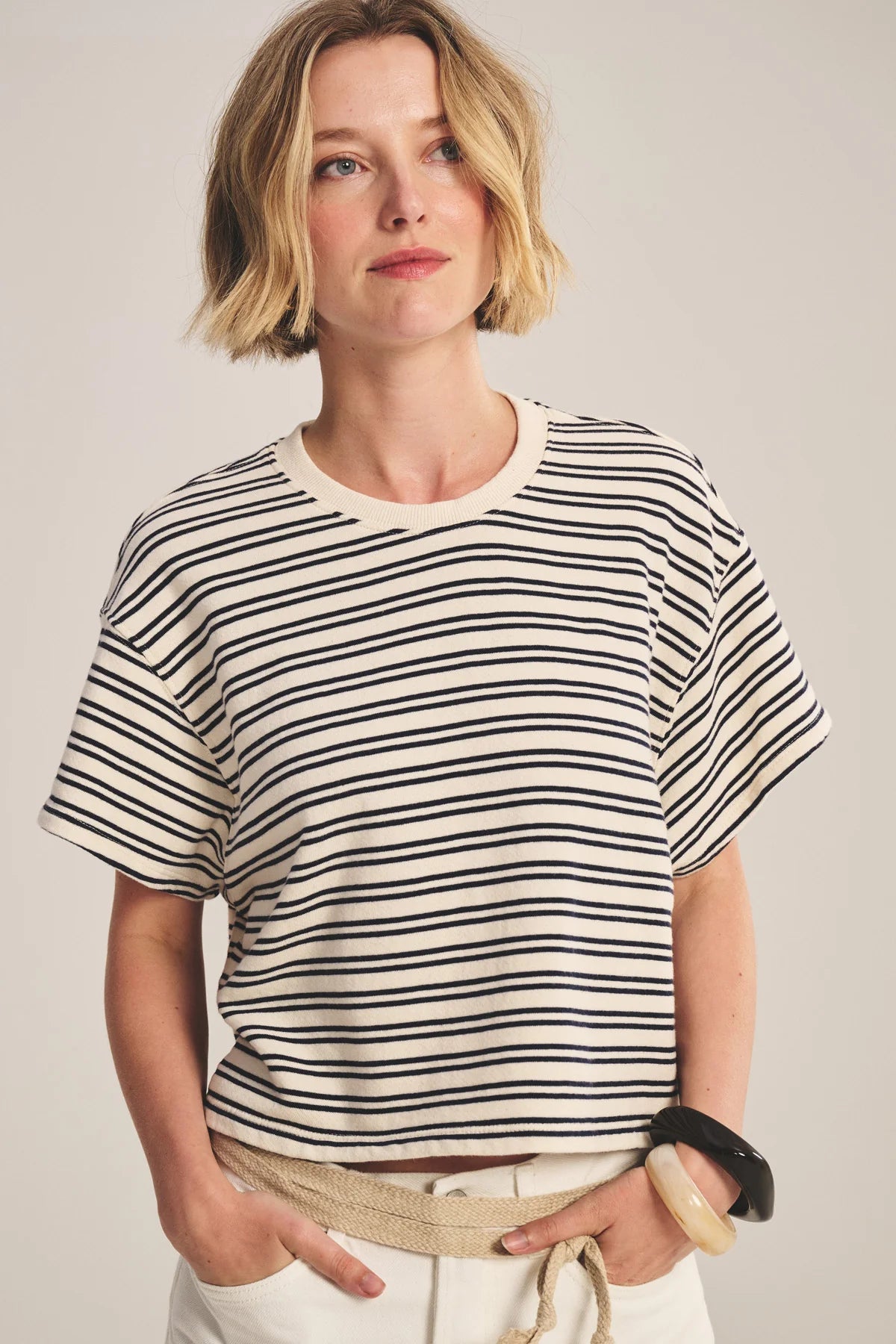 Woman wearing a black and white striped shirt against a plain background