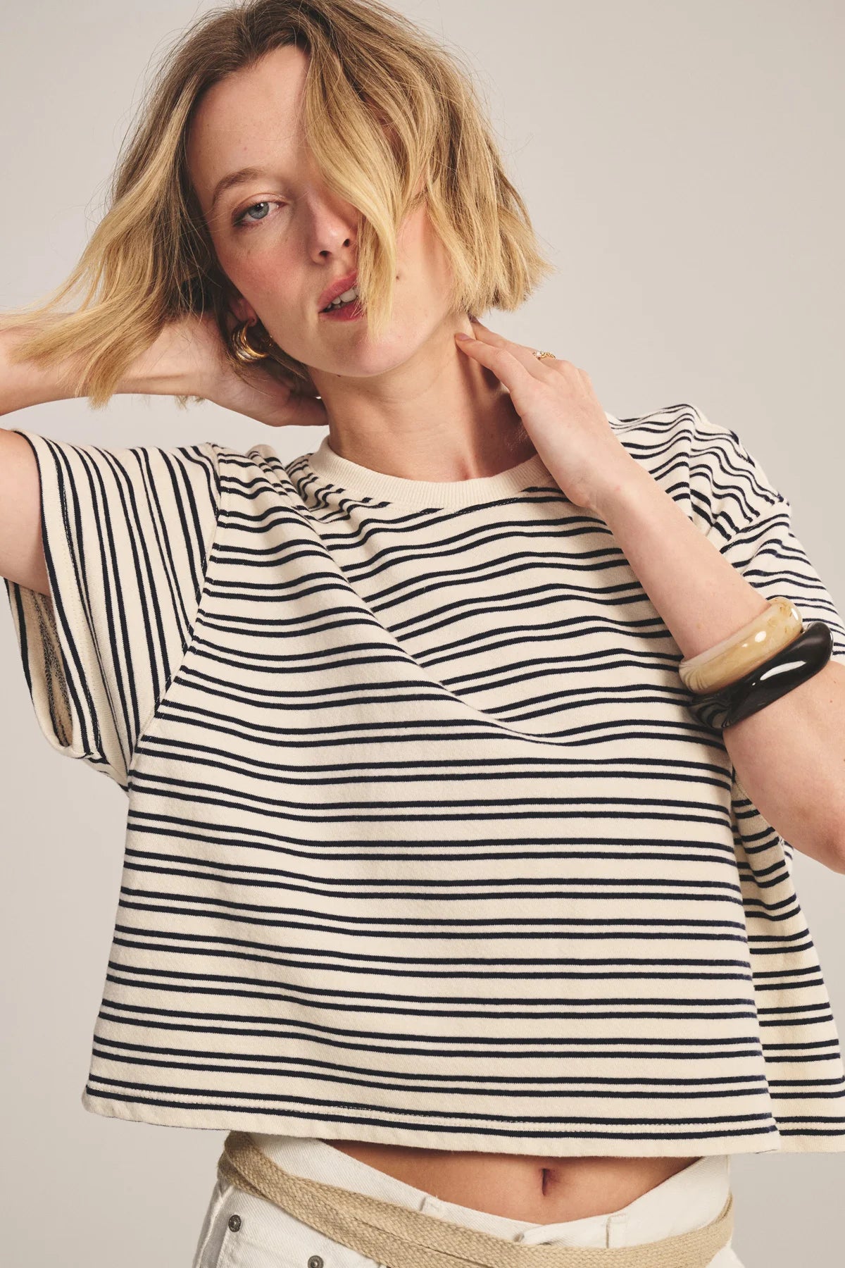 Woman wearing a black and white striped shirt with a neutral background