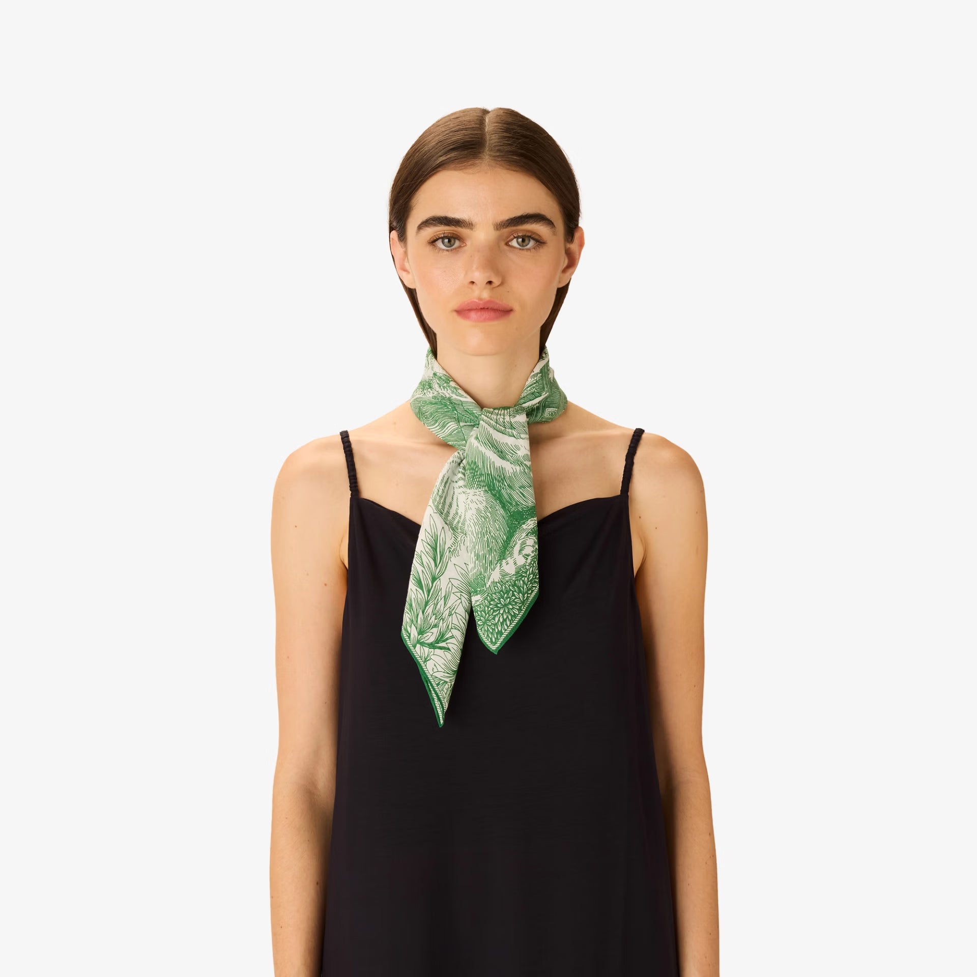 Woman wearing a green patterned scarf on a white background