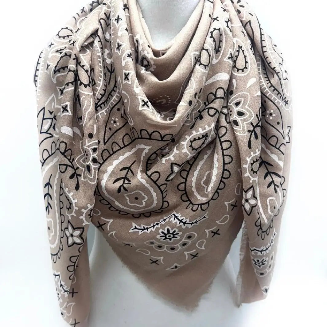Beige scarf with black paisley pattern draped over a mannequin on a white background