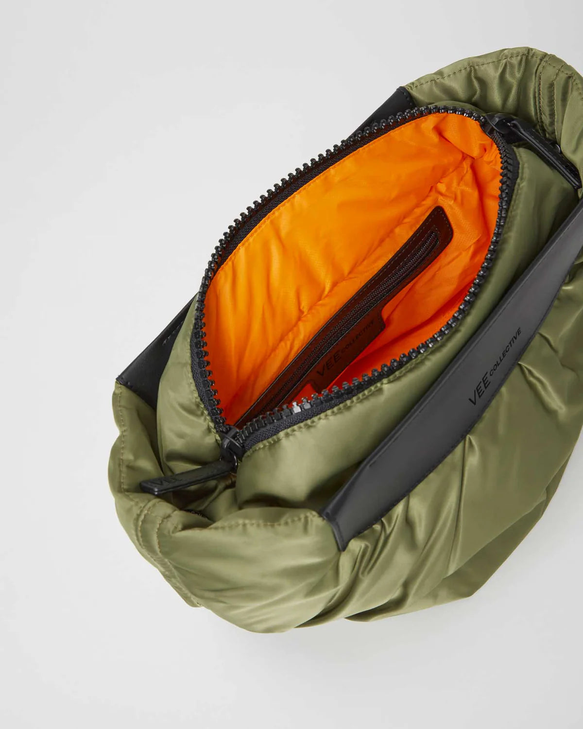 Green compression bag with orange interior on a white background
