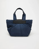 Blue tote bag with black handle and trim on a white background