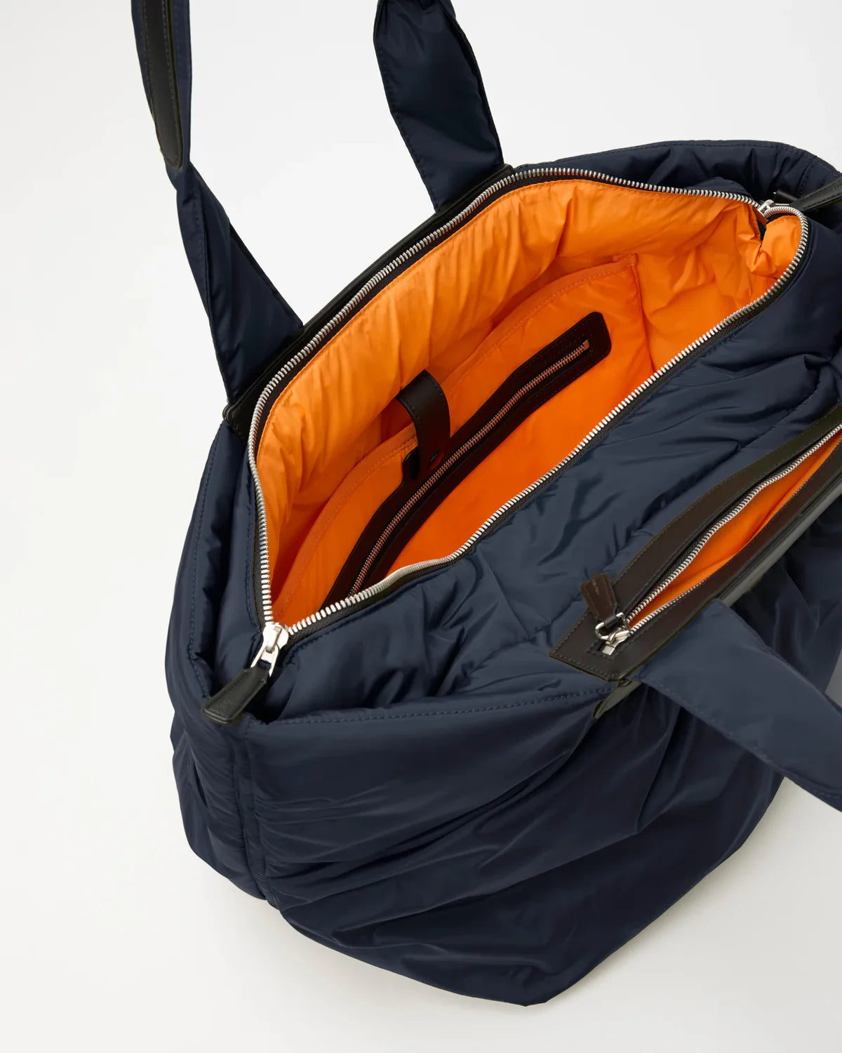 Navy blue backpack with orange interior on a white background