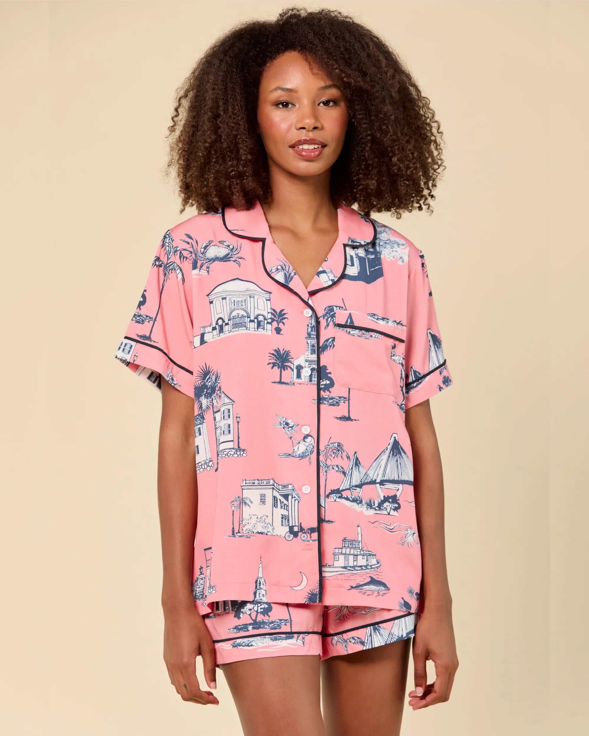 Woman wearing a pink pajama set with a pattern on a beige background
