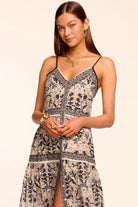 Woman wearing a black and white patterned dress on a beige background
