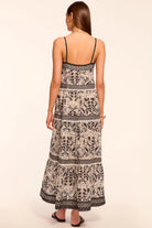 Woman wearing a patterned dress on a beige background