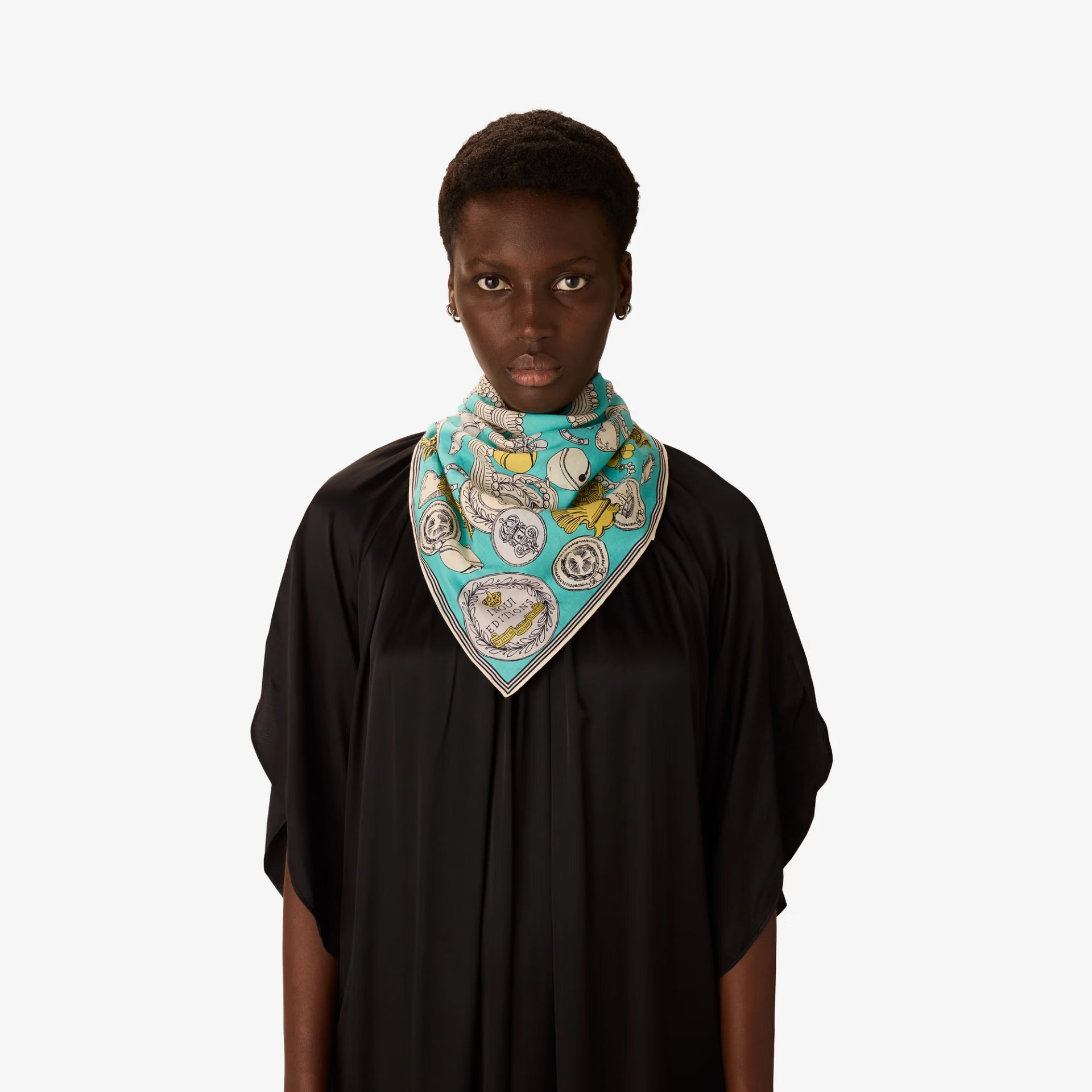 Person wearing a black top with a colorful patterned scarf on a white background