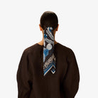 Person wearing a blue and white patterned headscarf on a plain background