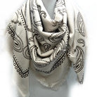 White scarf with black paisley patterns on a white background