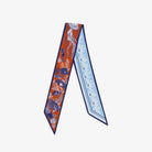 Two patterned scarves, one orange and blue, the other light blue with white designs, on a white background.