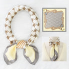 Silk scarf with geometric pattern on a mannequin, close-up inset showing design details.