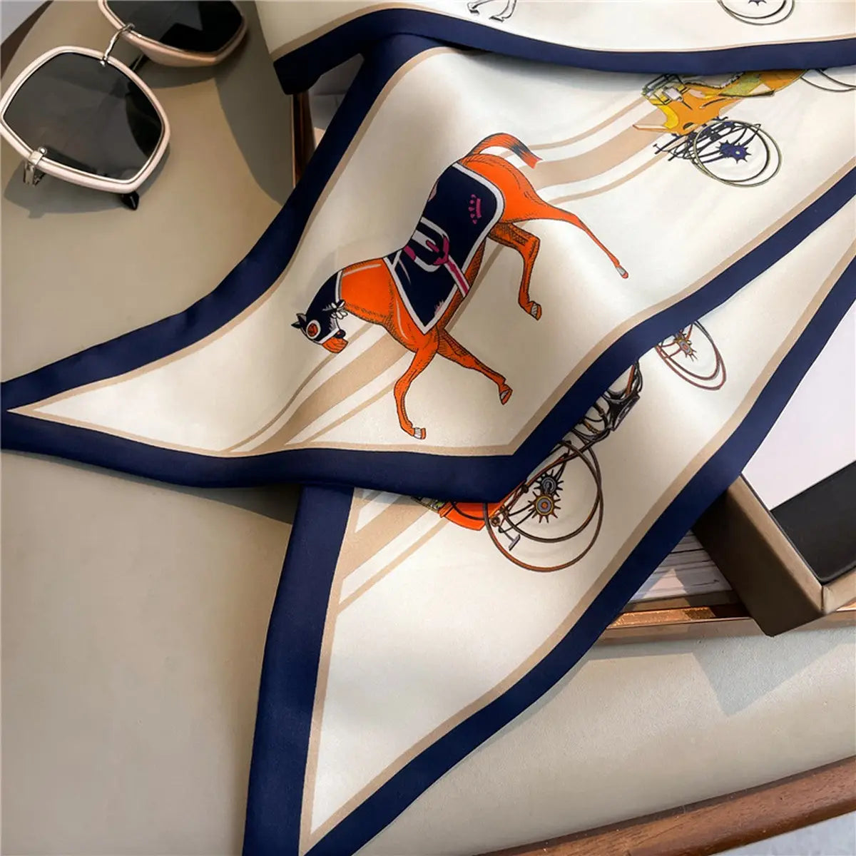 Silk scarf with horse and carriage design on a table