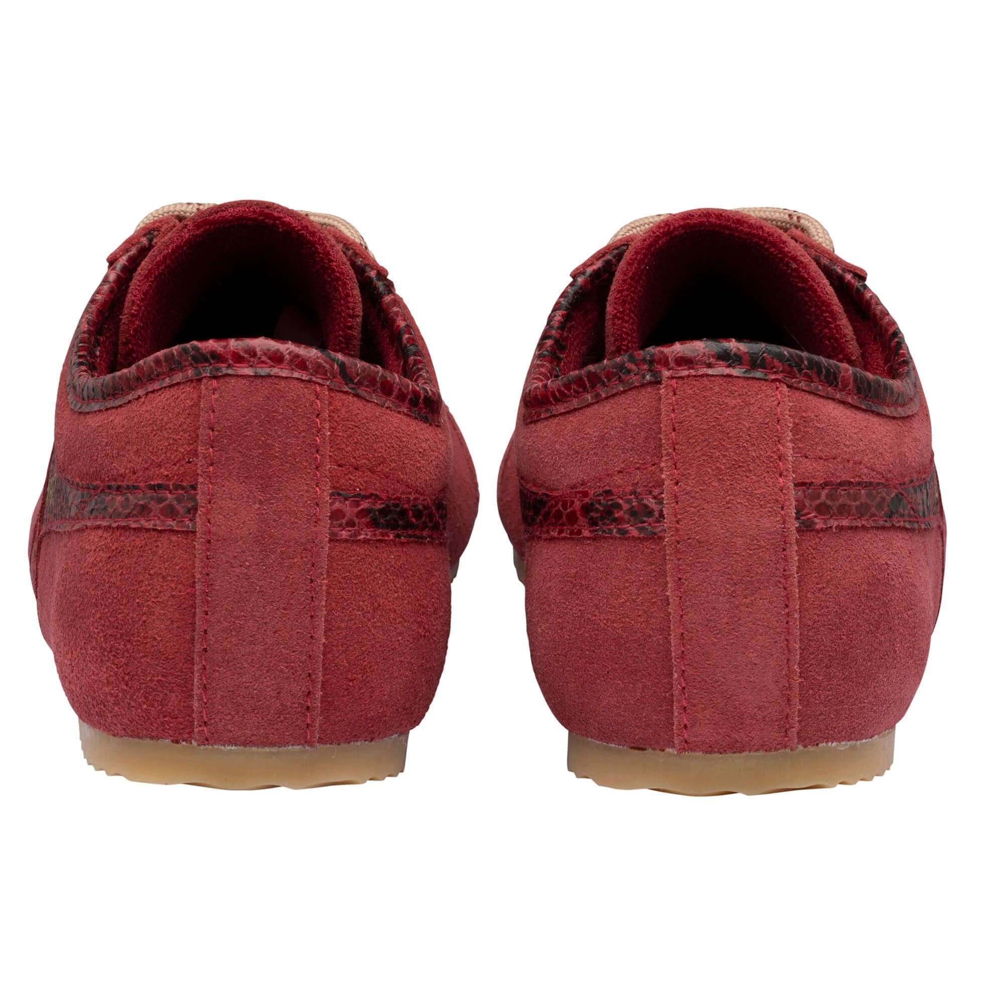 A pair of red suede slip-on shoes with dark red and black snakeskin-patterned trim and beige soles, shown from the back against a white background.
