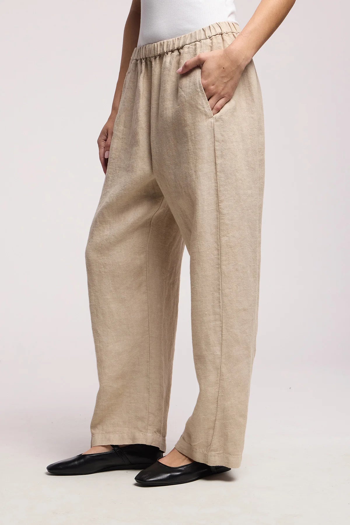 Beige pants worn by a person on a white background