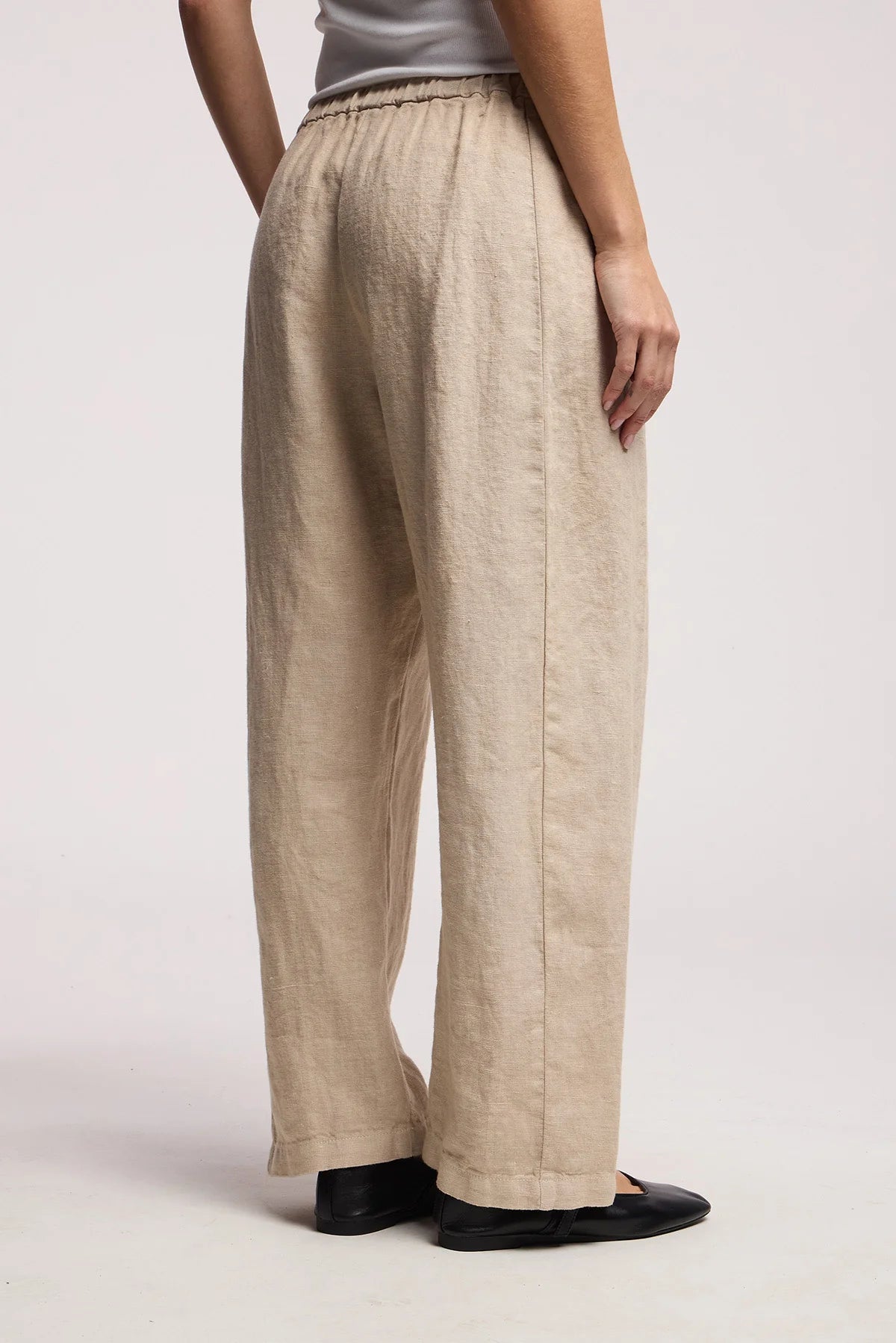 Beige linen pants worn by a person on a plain background