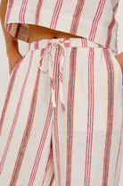 Striped pants with a tie waist on a neutral background