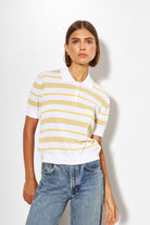 Woman wearing a white and yellow striped shirt with blue jeans on a white background
