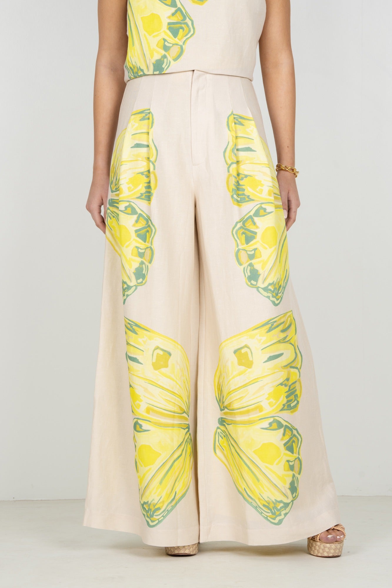 Person wearing a beige outfit with pineapple print on a plain background