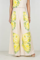 Person wearing a beige outfit with pineapple print on a plain background