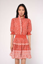 Woman wearing a red floral dress against a white background