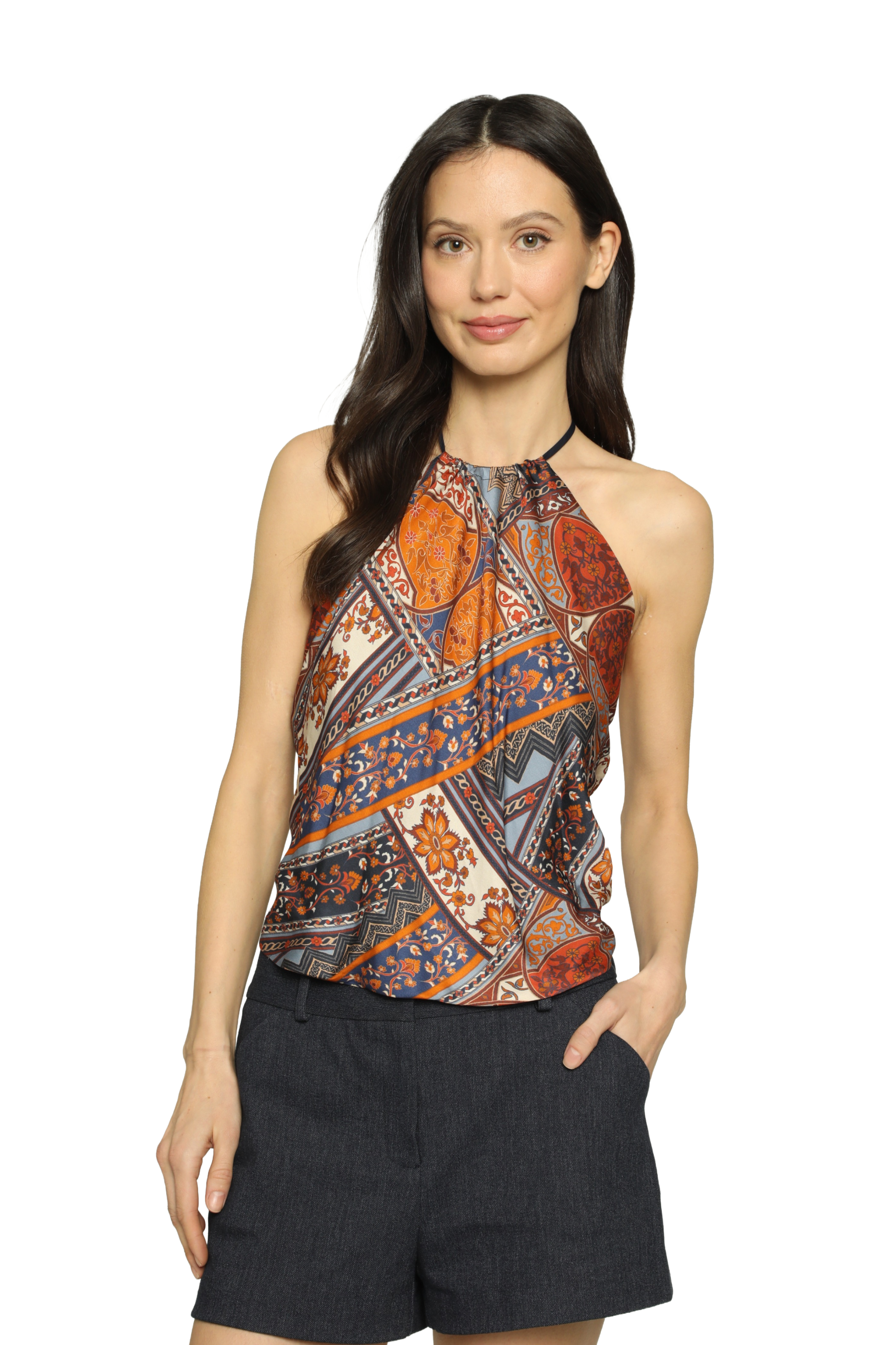 Woman wearing a patterned top and black shorts on a white background