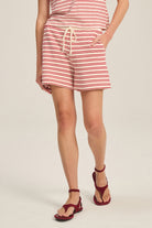 Person wearing a red and white striped dress with a plain background
