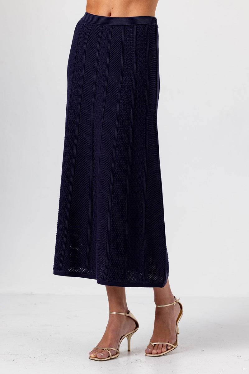 Navy blue textured skirt worn by a person on a white background