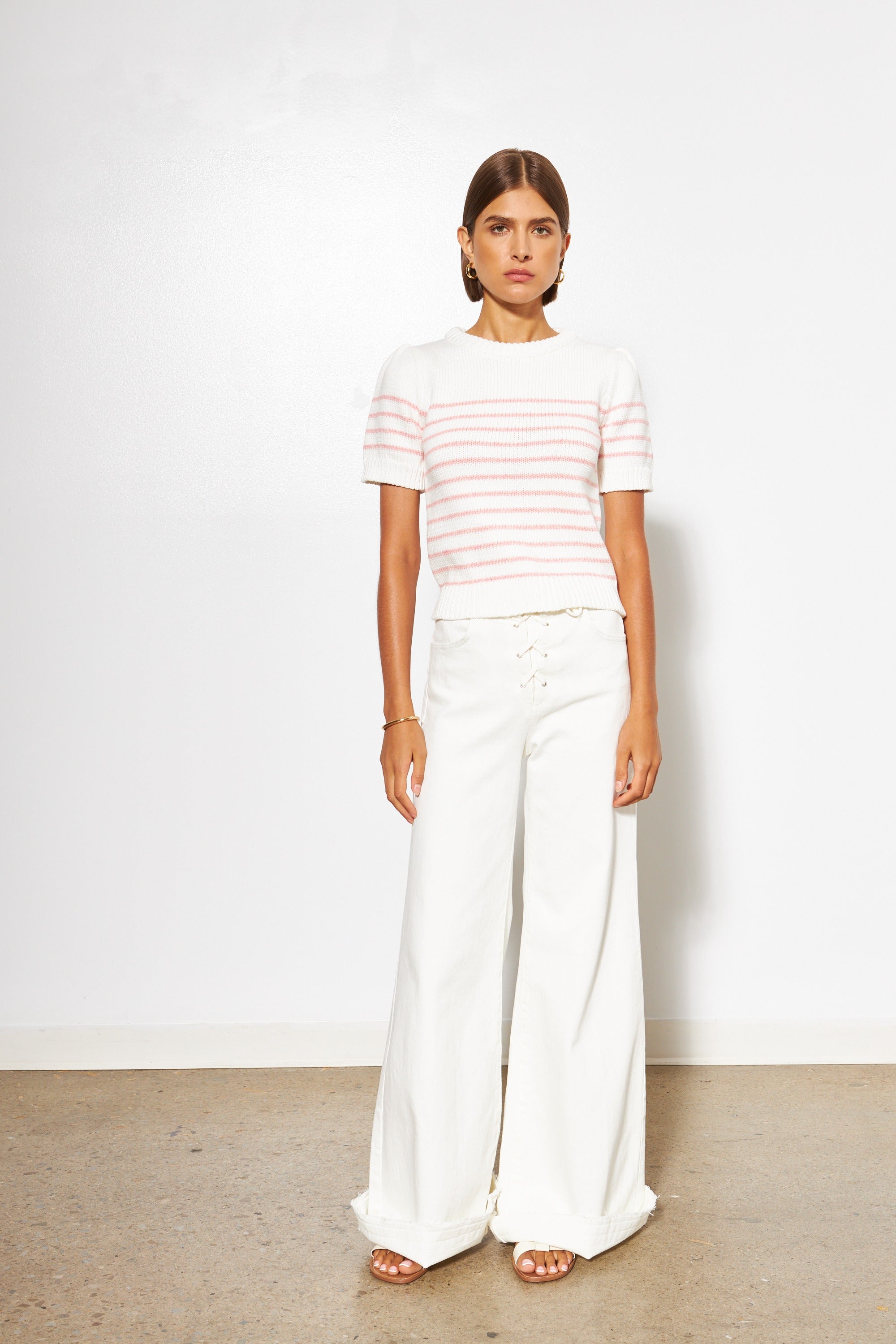 woman wearing white pants and white short sleeve sweater with red stripes