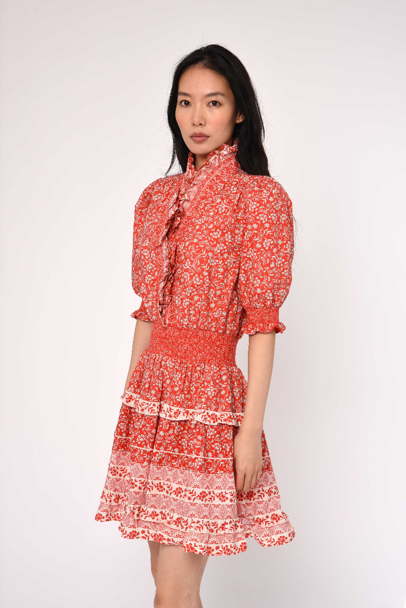 Woman wearing a red floral dress against a white background