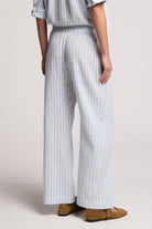 Person wearing a striped outfit with wide-leg pants on a plain background