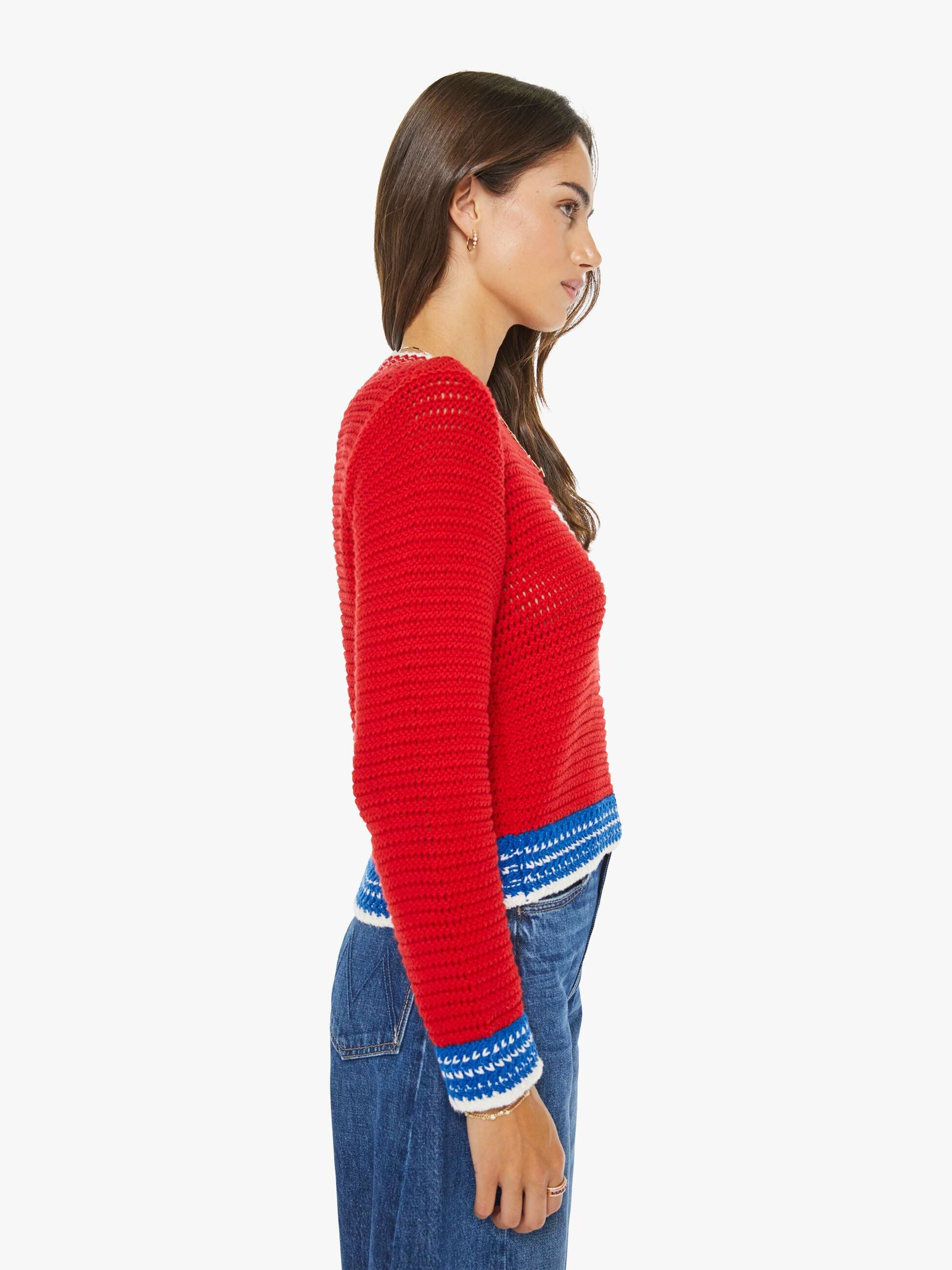 Woman wearing a red sweater with blue trim on a white background