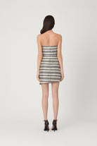 Woman wearing a strapless dress with a geometric pattern on a white background
