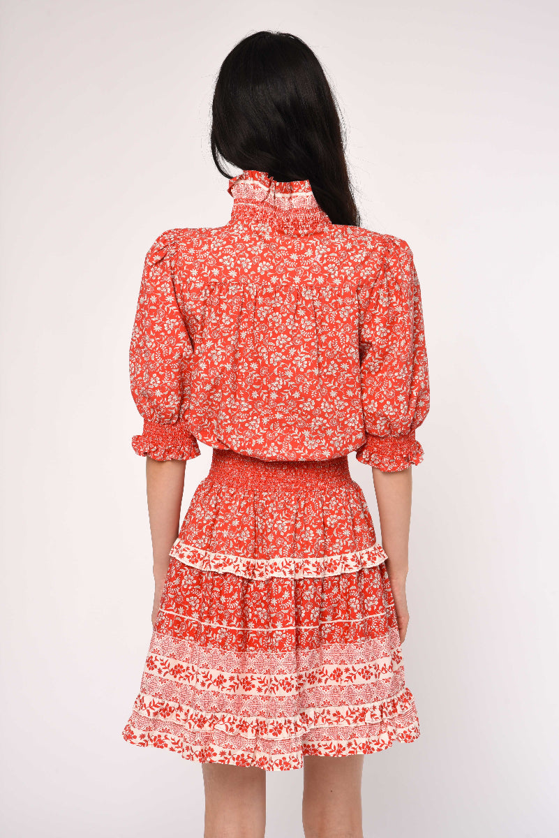 Woman wearing a red floral dress on a white background