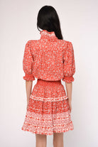 Woman wearing a red floral dress on a white background