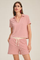 Woman wearing a red and white striped outfit on a beige background