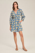 Woman wearing a blue floral dress on a beige background
