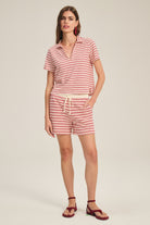 Woman wearing a red and white striped outfit on a beige background