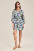 Woman wearing a floral dress on a plain background