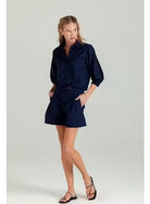Woman wearing a navy blue dress on a light gray background